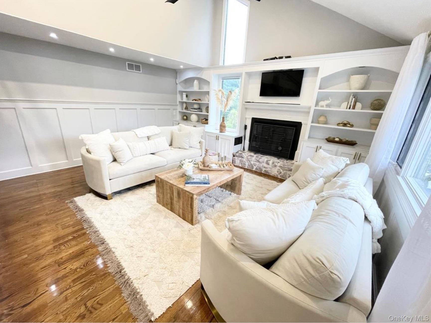51 Cheviot Road Southampton, NY 11968 - Photo 5 of 22 a living room with furniture a flat screen tv and a fireplace