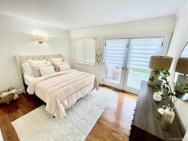 a bedroom with a bed potted plant with the wooden floor