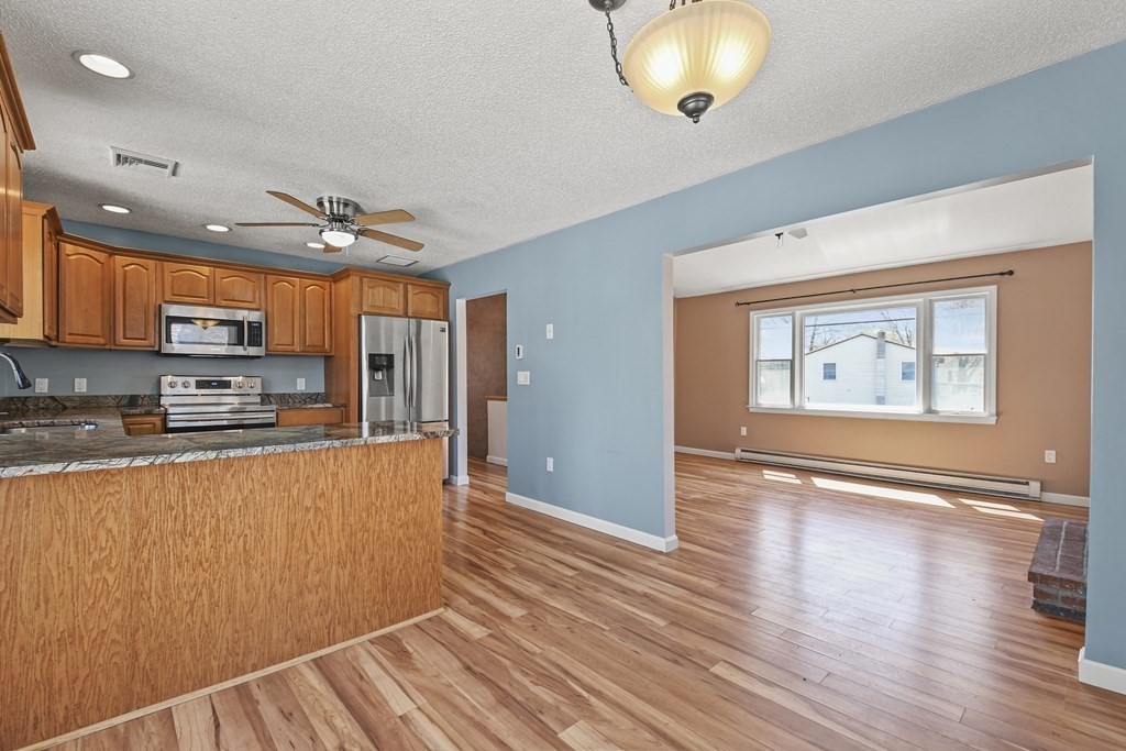5 Jackson Road Webster, MA 01570 - Photo 11 of 30 a open kitchen with stainless steel appliances granite countertop a refrigerator a stove top oven and wooden floor
