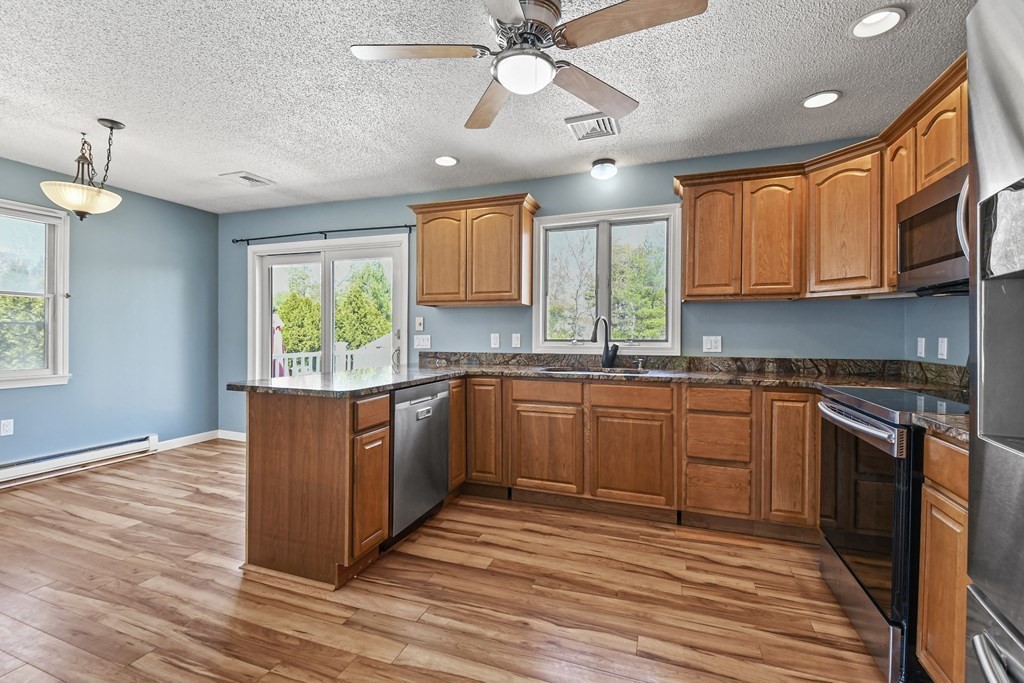 5 Jackson Road Webster, MA 01570 - Photo 7 of 30 a kitchen with stainless steel appliances granite countertop a stove a sink dishwasher and a refrigerator with wooden floor