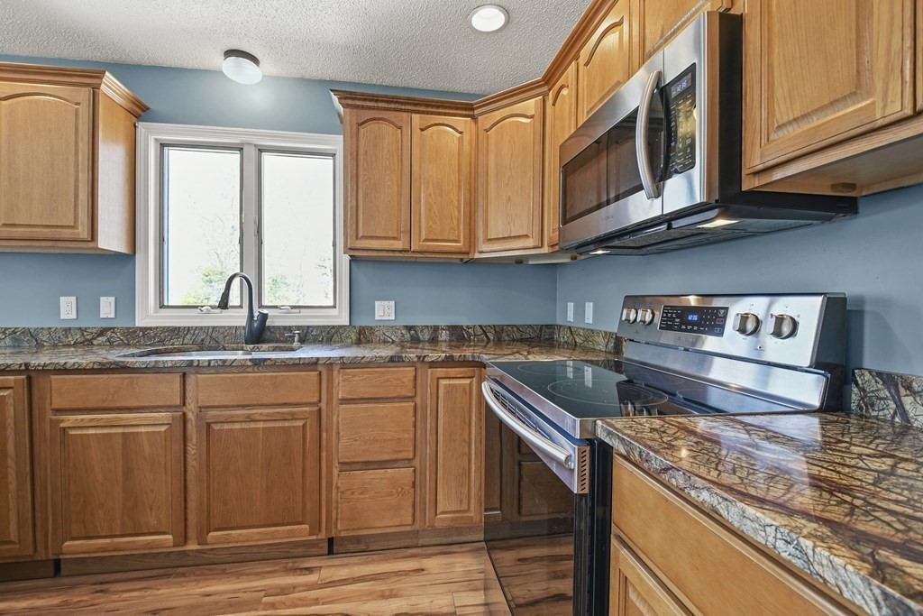 5 Jackson Road Webster, MA 01570 - Photo 8 of 30 a kitchen with stainless steel appliances granite countertop a sink stove and cabinets