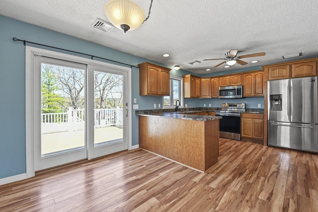 5 Jackson Road Webster, MA 01570 - Photo 10 of 30 a kitchen with stainless steel appliances granite countertop a refrigerator a sink dishwasher a stove and white countertops with wooden floor