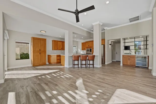 a view of a livingroom with furniture and kitchen with furniture wooden floor and window