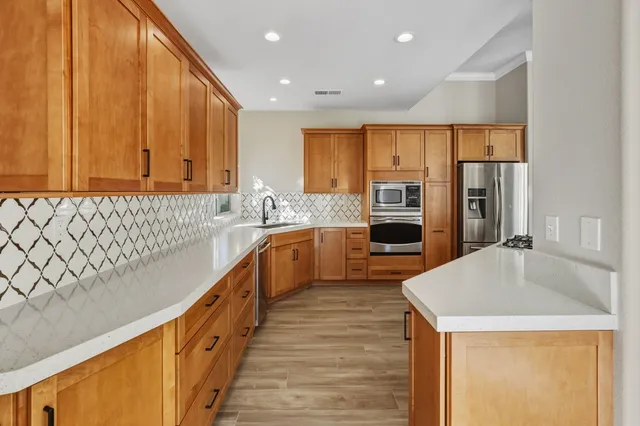 a kitchen with stainless steel appliances granite countertop a sink refrigerator and cabinets