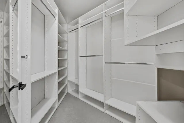 a view of walk in closet with empty racks