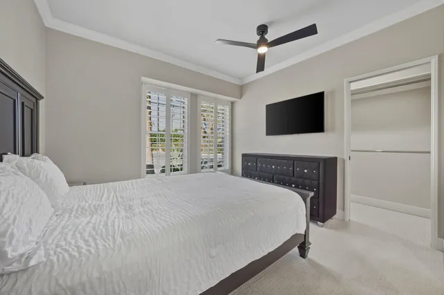 a bedroom with a bed tv and a window