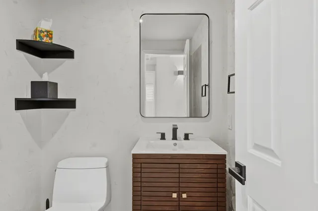 a bathroom with a sink a toilet and mirror