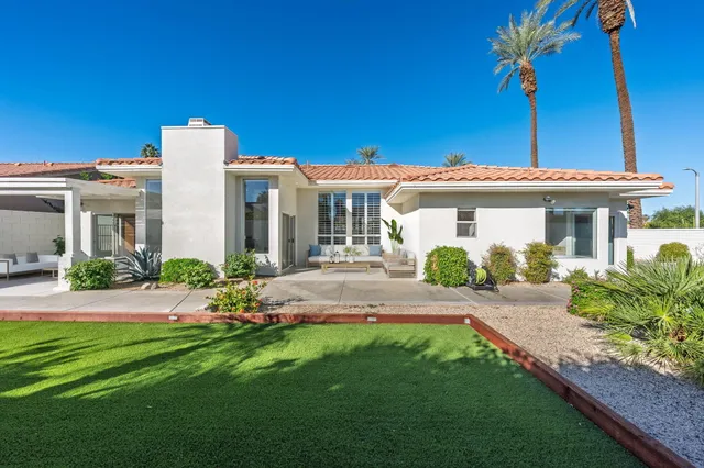 a front view of a house with a garden and yard