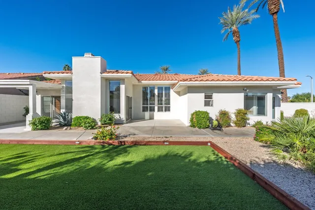 a front view of a house with a garden and yard