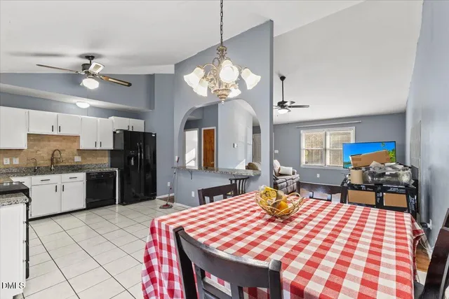 a open kitchen with stainless steel appliances granite countertop a sink dishwasher and a refrigerator with wooden floor