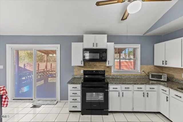 a kitchen with granite countertop a stove and cabinets