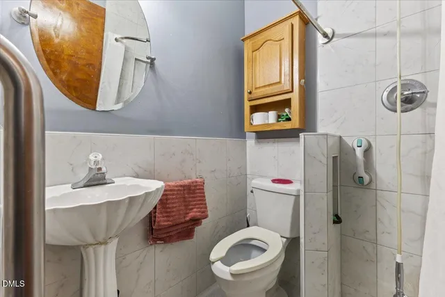 a bathroom with a sink a toilet and a mirror