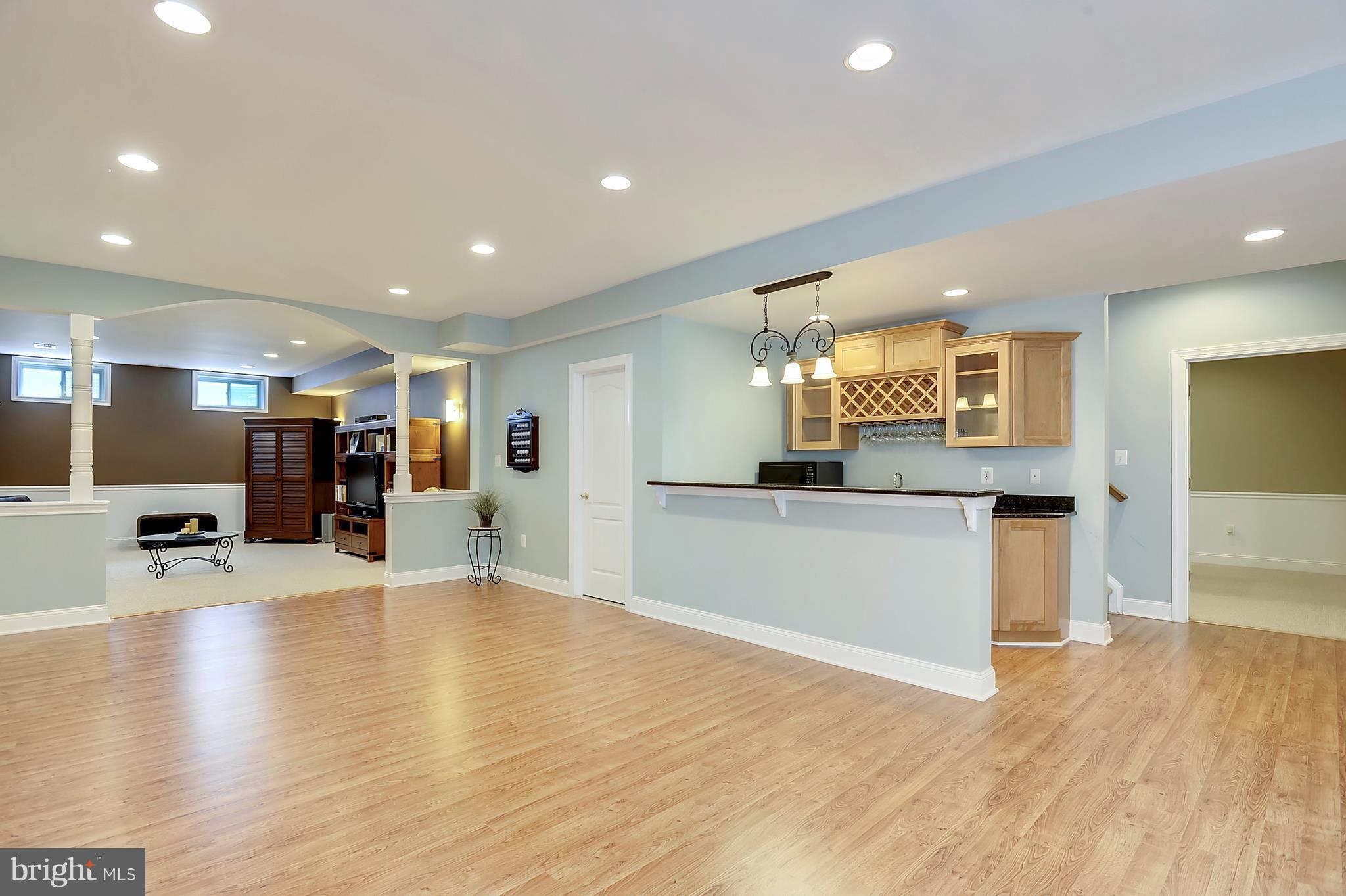 4855 Muddler Way Fairfax, VA 22030 - Photo 23 of 30 a view of large living room with kitchen island stainless steel appliances refrigerator stove and wooden floor