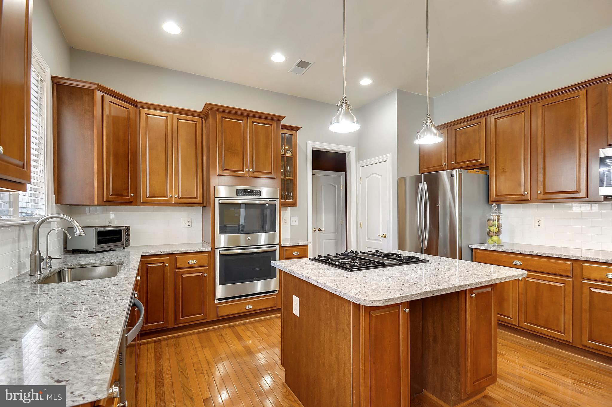 4855 Muddler Way Fairfax, VA 22030 - Photo 10 of 30 a kitchen with stainless steel appliances granite countertop a sink stove and refrigerator