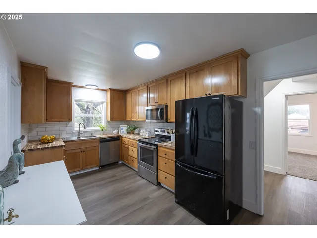 a kitchen with a refrigerator and a stove top oven