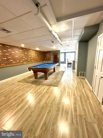 a room with wooden floor table tennis pool table and chairs