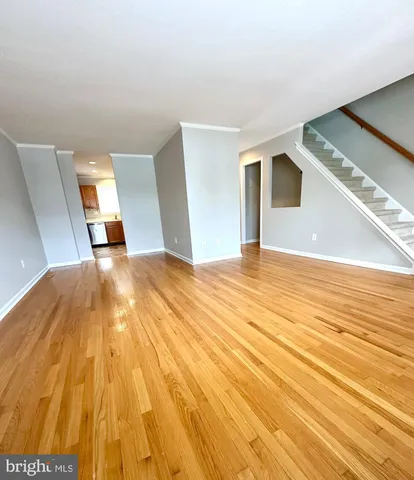 a view of empty room with wooden floor