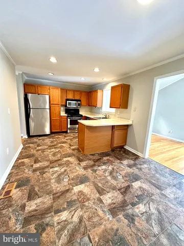 a view of a kitchen with sink microwave and cabinets