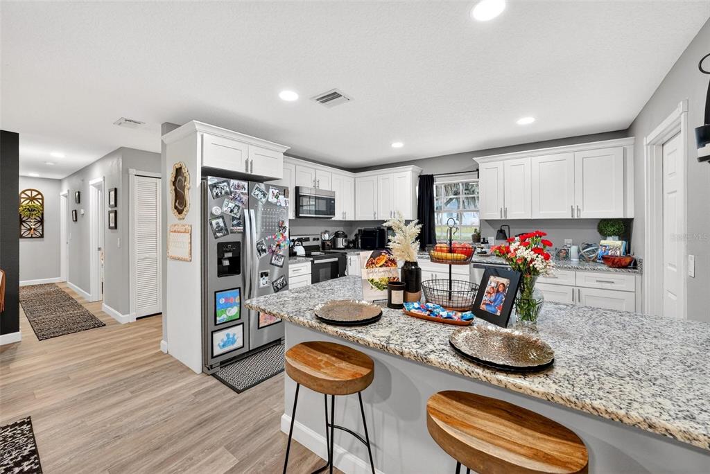 106 Portland Street Eustis, FL 32726 - Photo 24 of 71 a kitchen with stainless steel appliances granite countertop a refrigerator and a stove top oven