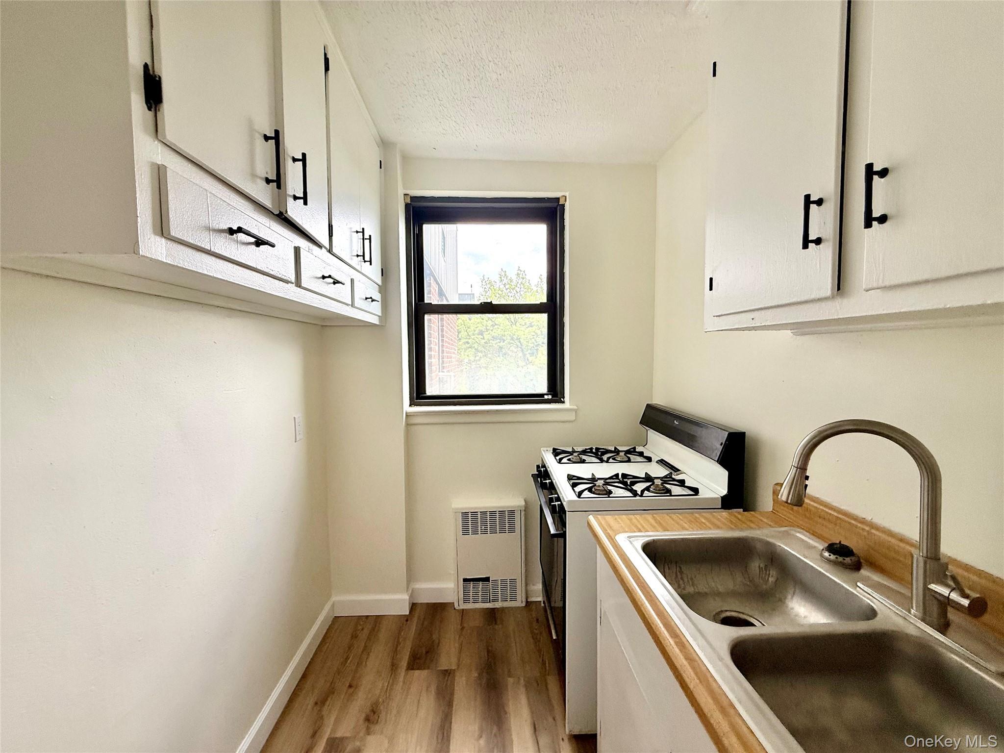 112-25 34th Avenue, Unit 6H Queens, NY 11368 - Photo 12 of 48 Kitchen with original wood cabinets, stainless steel sink, plenty of cabinets, large window for ventilation.