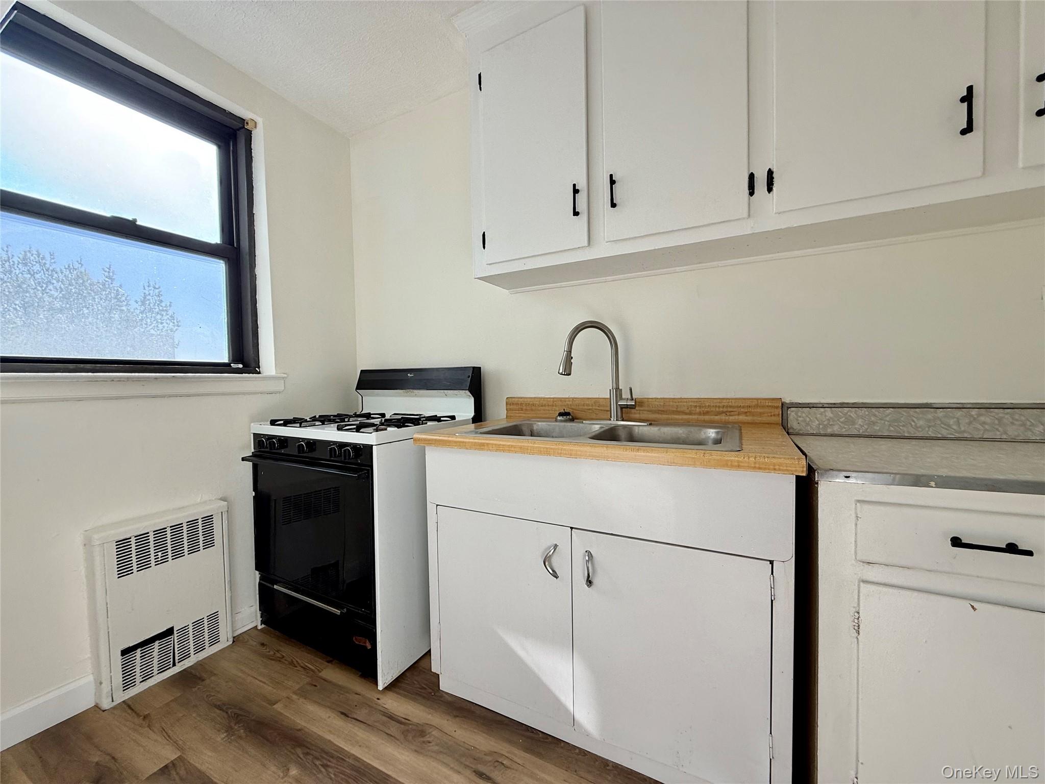 112-25 34th Avenue, Unit 6H Queens, NY 11368 - Photo 15 of 48 Kitchen with original wood cabinets, stainless steel sink, plenty of cabinets, large window for ventilation.