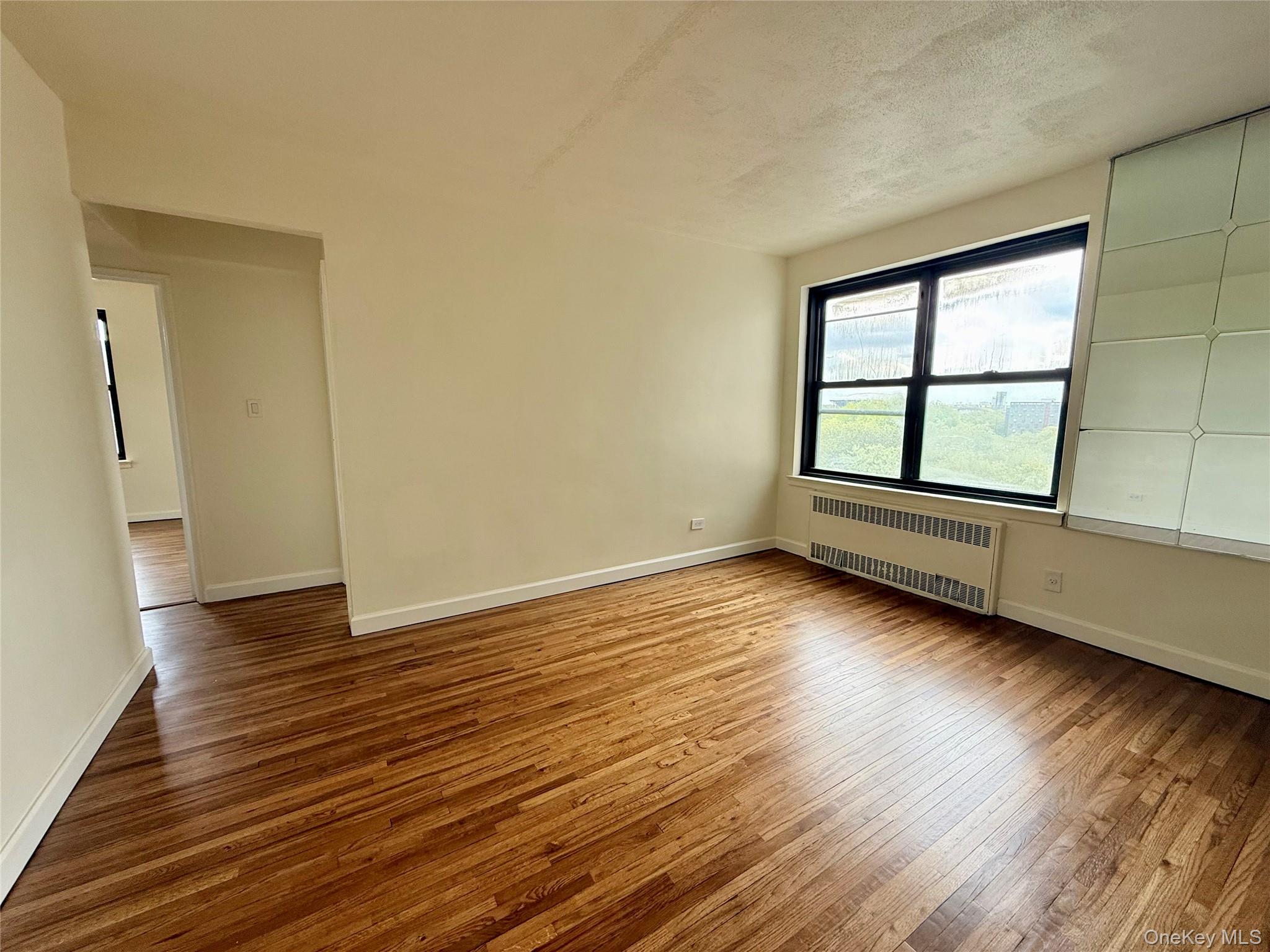112-25 34th Avenue, Unit 6H Queens, NY 11368 - Photo 2 of 48 Large living room with double panel window, top floor provides excellent natural light, hardwood floors. Open to the dining area and kitchen.