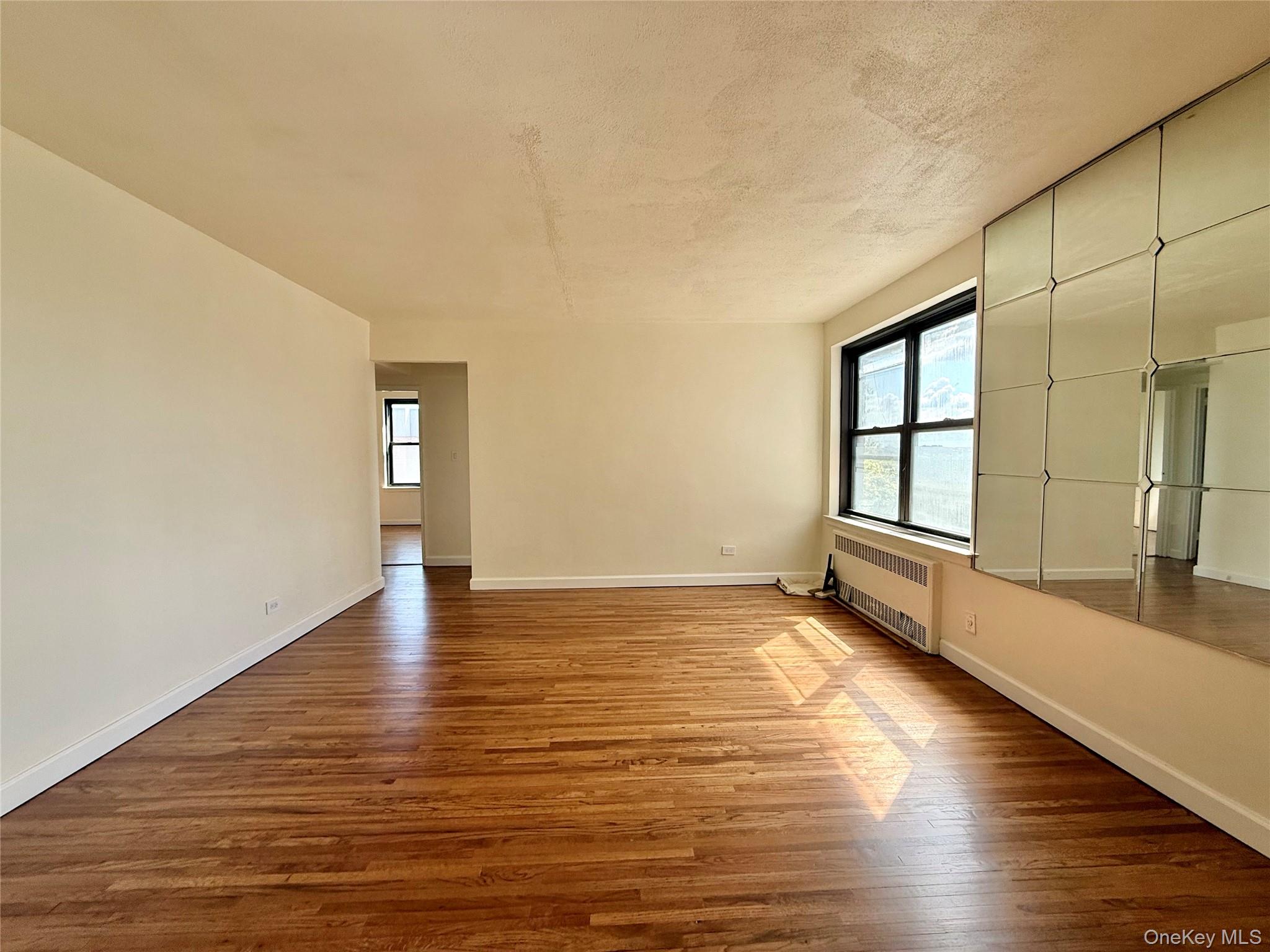 112-25 34th Avenue, Unit 6H Queens, NY 11368 - Photo 4 of 48 Large living room with double panel window, top floor provides excellent natural light, hardwood floors. Open to the dining area and kitchen.