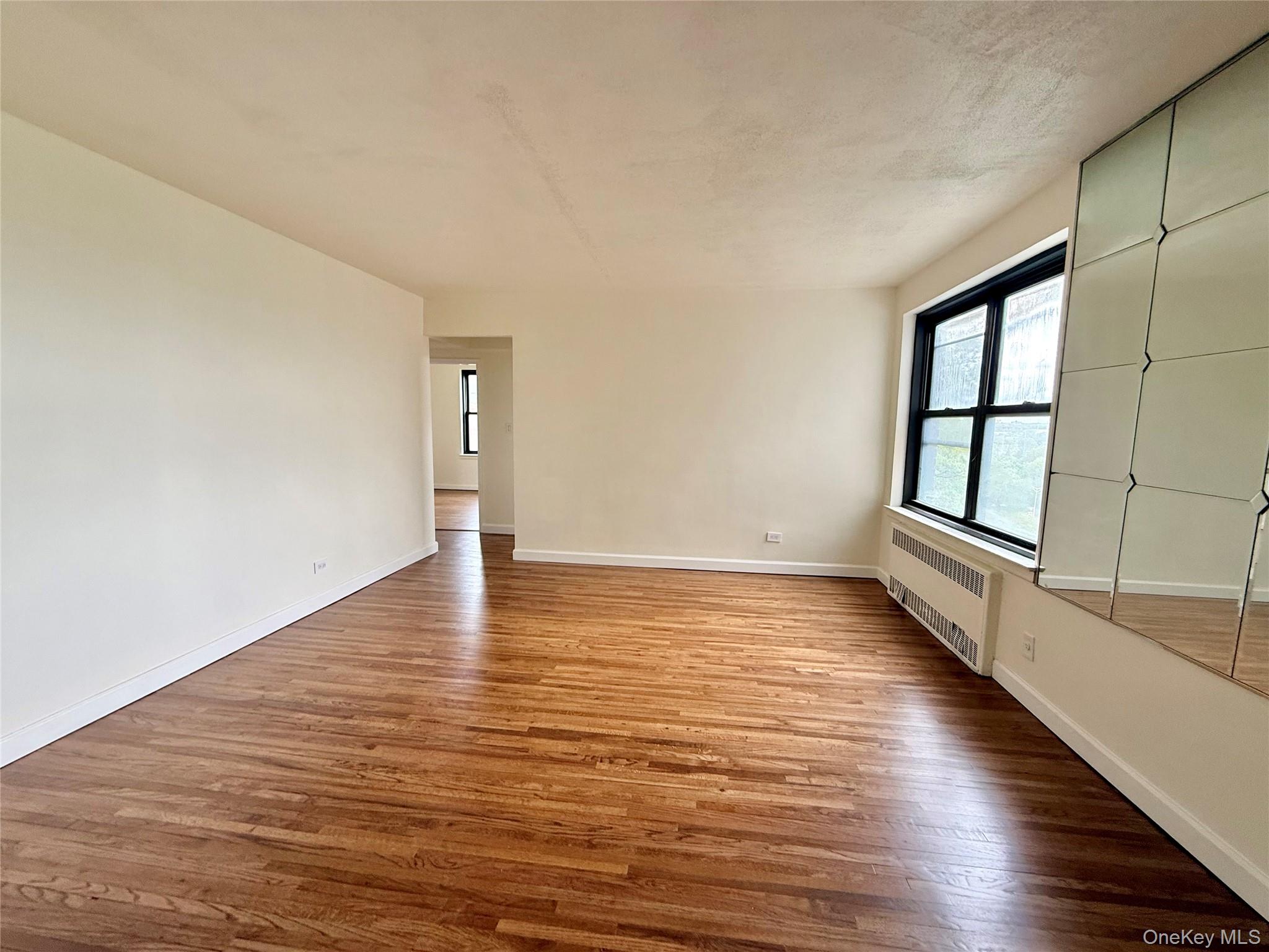 112-25 34th Avenue, Unit 6H Queens, NY 11368 - Photo 5 of 48 Large living room with double panel window, top floor provides excellent natural light, hardwood floors. Open to the dining area and kitchen.
