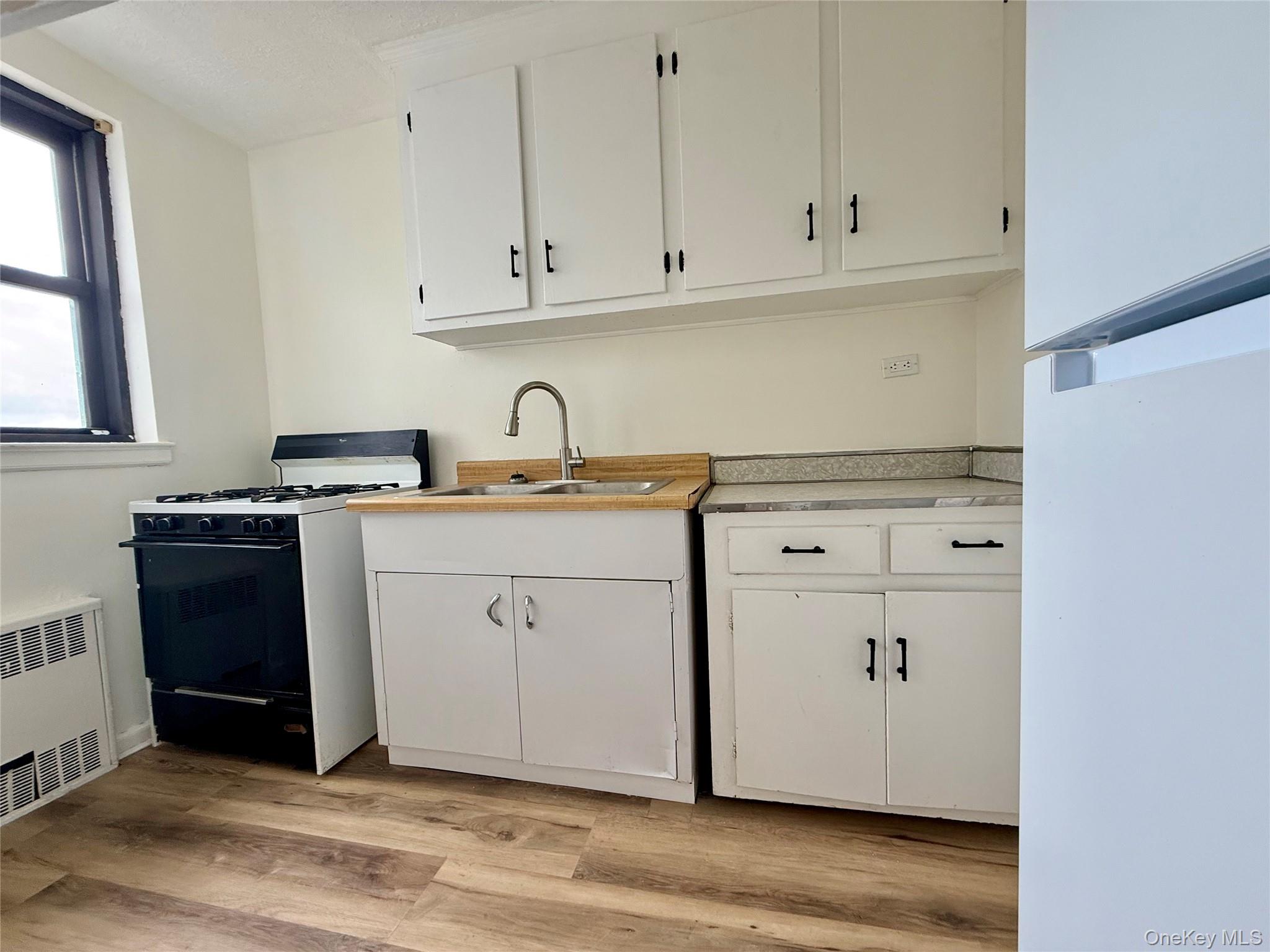 112-25 34th Avenue, Unit 6H Queens, NY 11368 - Photo 10 of 48 Kitchen with original wood cabinets, stainless steel sink, plenty of cabinets, large window for ventilation.