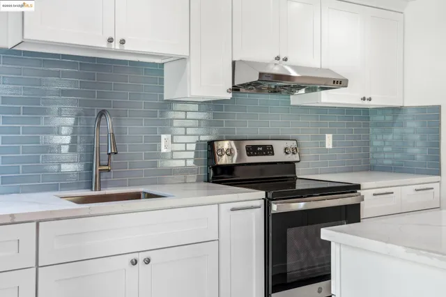 a kitchen with granite countertop cabinets a stove and a sink