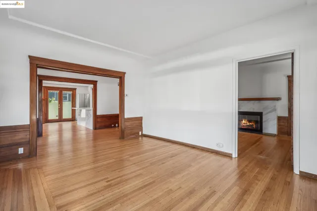 a view of empty room with wooden floor and fireplace