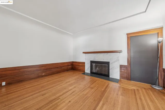 a view of empty room with wooden floor and fireplace