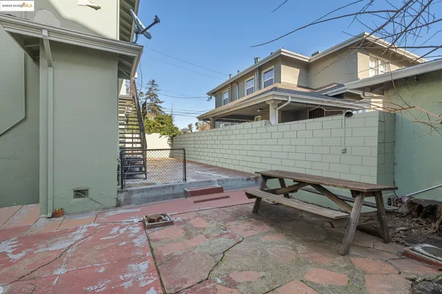 a view of a patio with table and chairs with wooden fence and plants