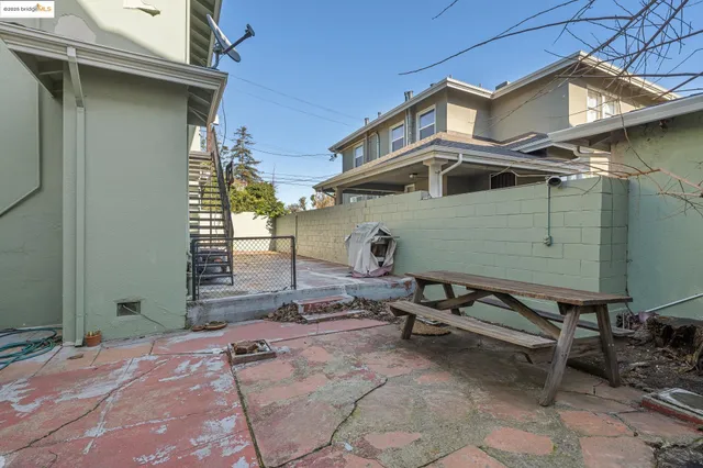 a view of a patio with table and chairs with wooden fence and plants