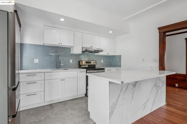 a kitchen with stainless steel appliances white cabinets and a refrigerator