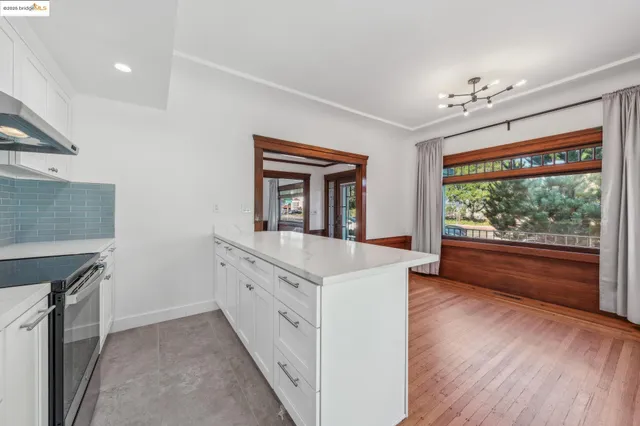 a open kitchen with granite countertop a stove top oven sink and wooden floor