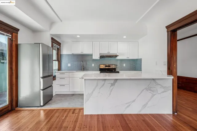 a kitchen with stainless steel appliances a refrigerator and wooden floor