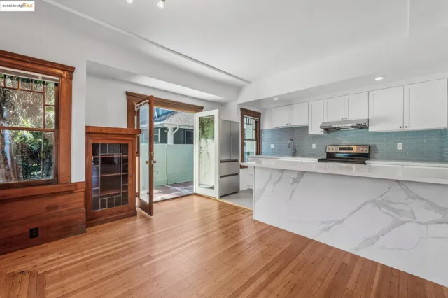 a kitchen with stainless steel appliances granite countertop a refrigerator a stove and a wooden floors