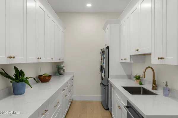 a kitchen with white cabinets a sink and dishwasher