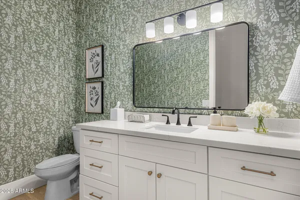 a bathroom with a toilet sink and mirror