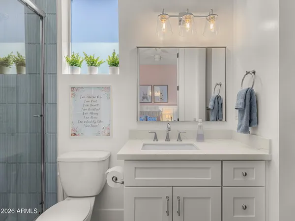 a bathroom with a sink a toilet and shower