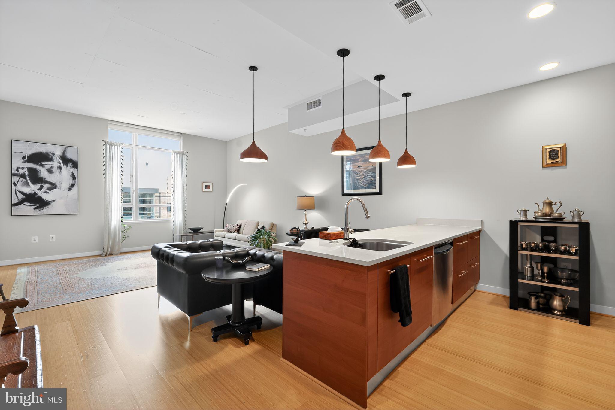 12025 New Dominion Parkway, Unit 311 Reston, VA 20190 - Photo 13 of 29 a kitchen with a stove and a wooden floor