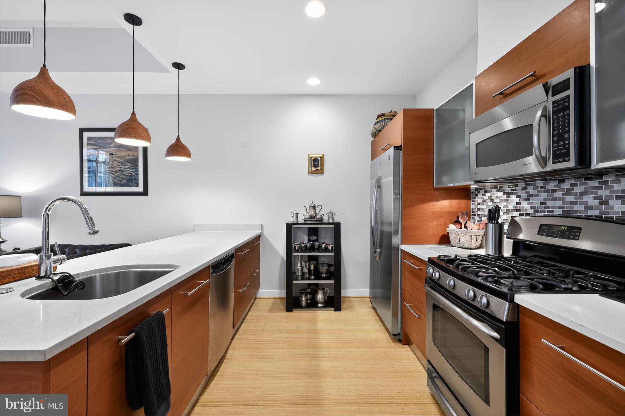 12025 New Dominion Parkway, Unit 311 Reston, VA 20190 - Photo 14 of 29 a kitchen with stainless steel appliances granite countertop a sink and a stove