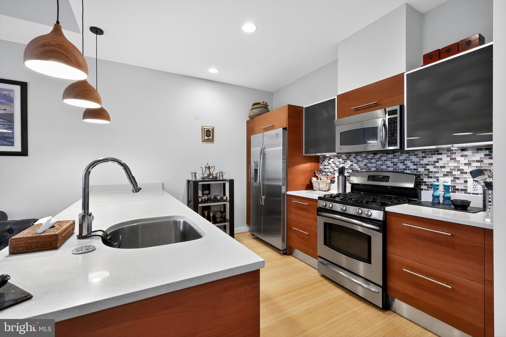 12025 New Dominion Parkway, Unit 311 Reston, VA 20190 - Photo 15 of 29 a kitchen with a sink and a stove top oven
