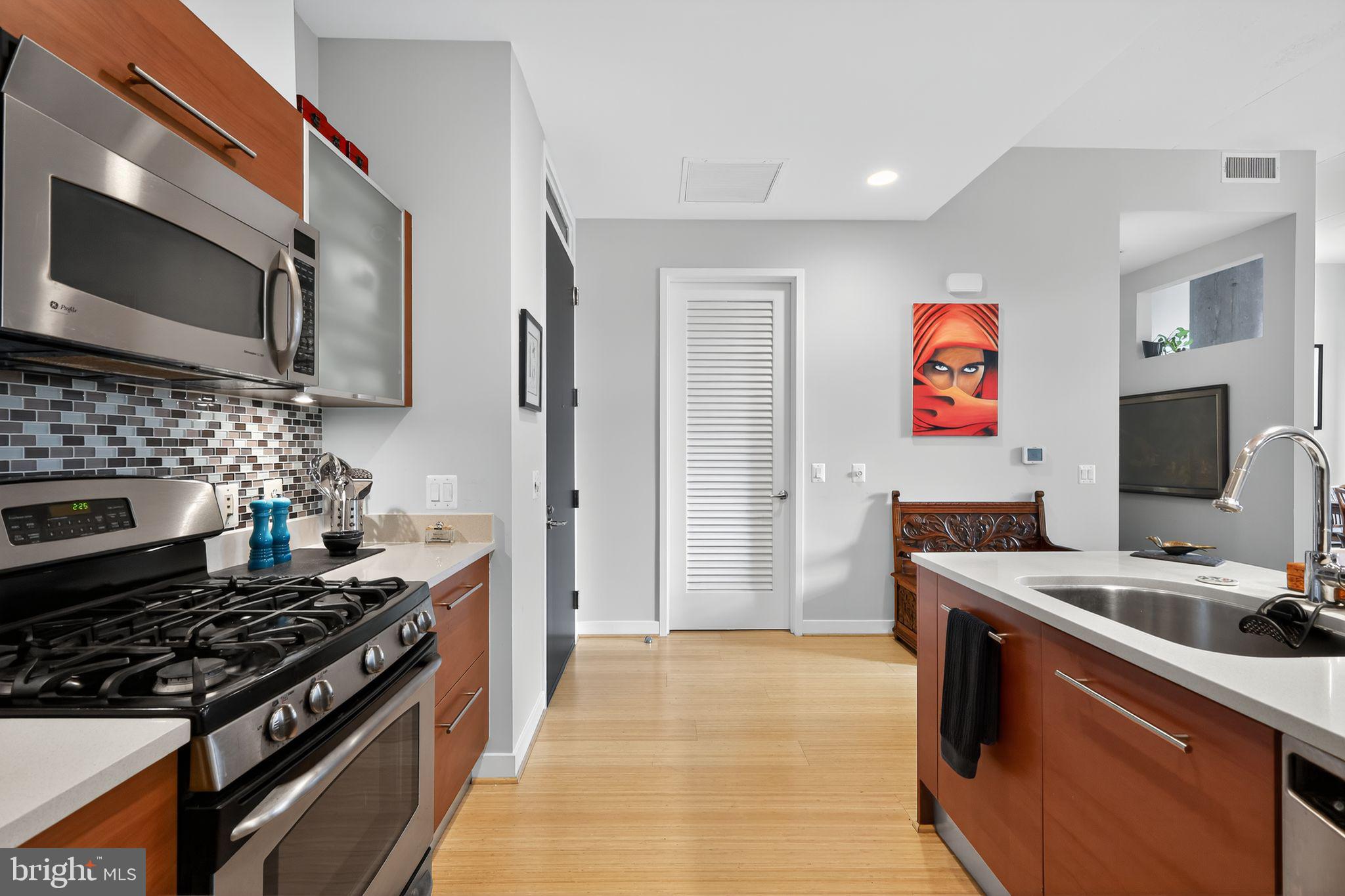 12025 New Dominion Parkway, Unit 311 Reston, VA 20190 - Photo 16 of 29 a kitchen with stainless steel appliances granite countertop a stove a sink and a microwave