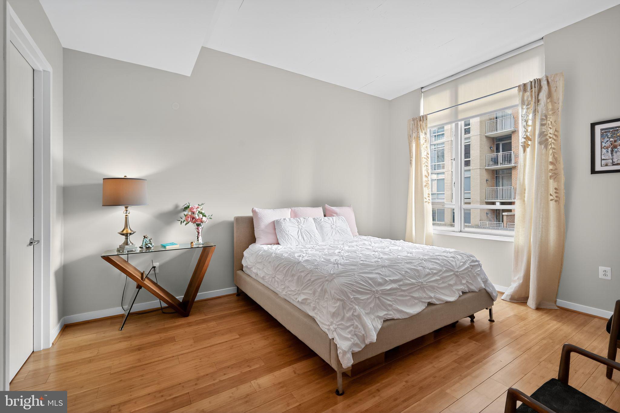 12025 New Dominion Parkway, Unit 311 Reston, VA 20190 - Photo 19 of 29 a bedroom with a bed and wooden floor