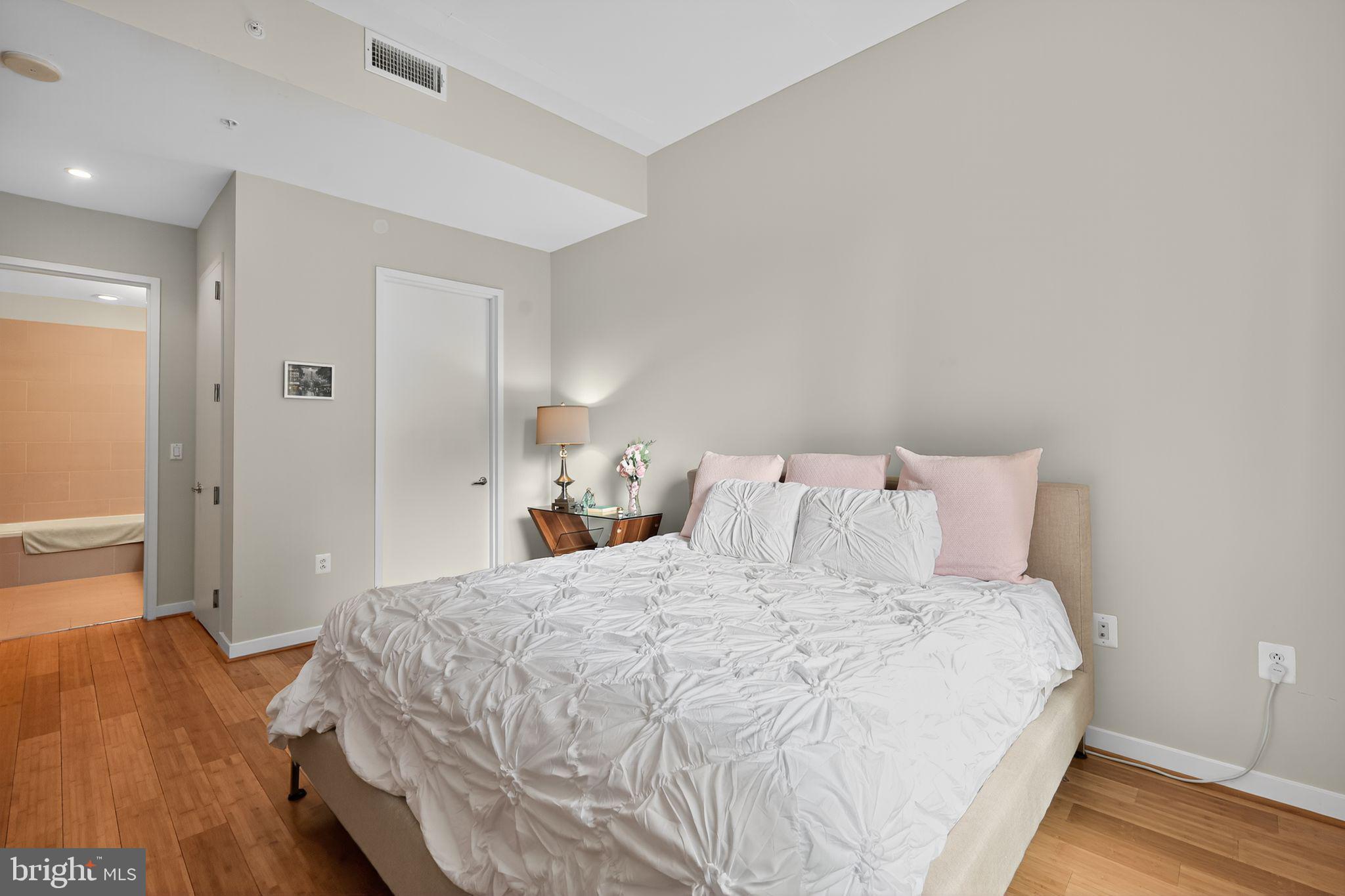 12025 New Dominion Parkway, Unit 311 Reston, VA 20190 - Photo 20 of 29 a large bed sitting in a bedroom and table