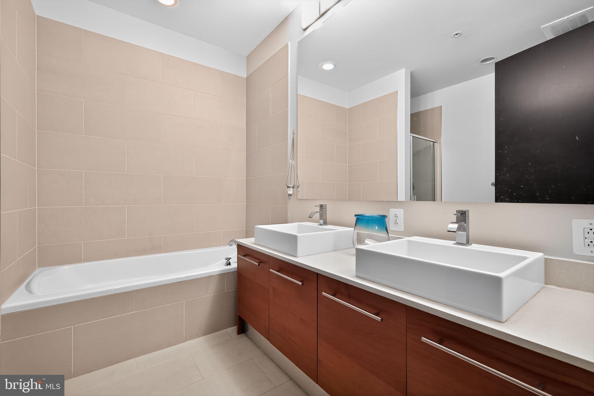 12025 New Dominion Parkway, Unit 311 Reston, VA 20190 - Photo 22 of 29 a bathroom with a sink a bathtub and a mirror