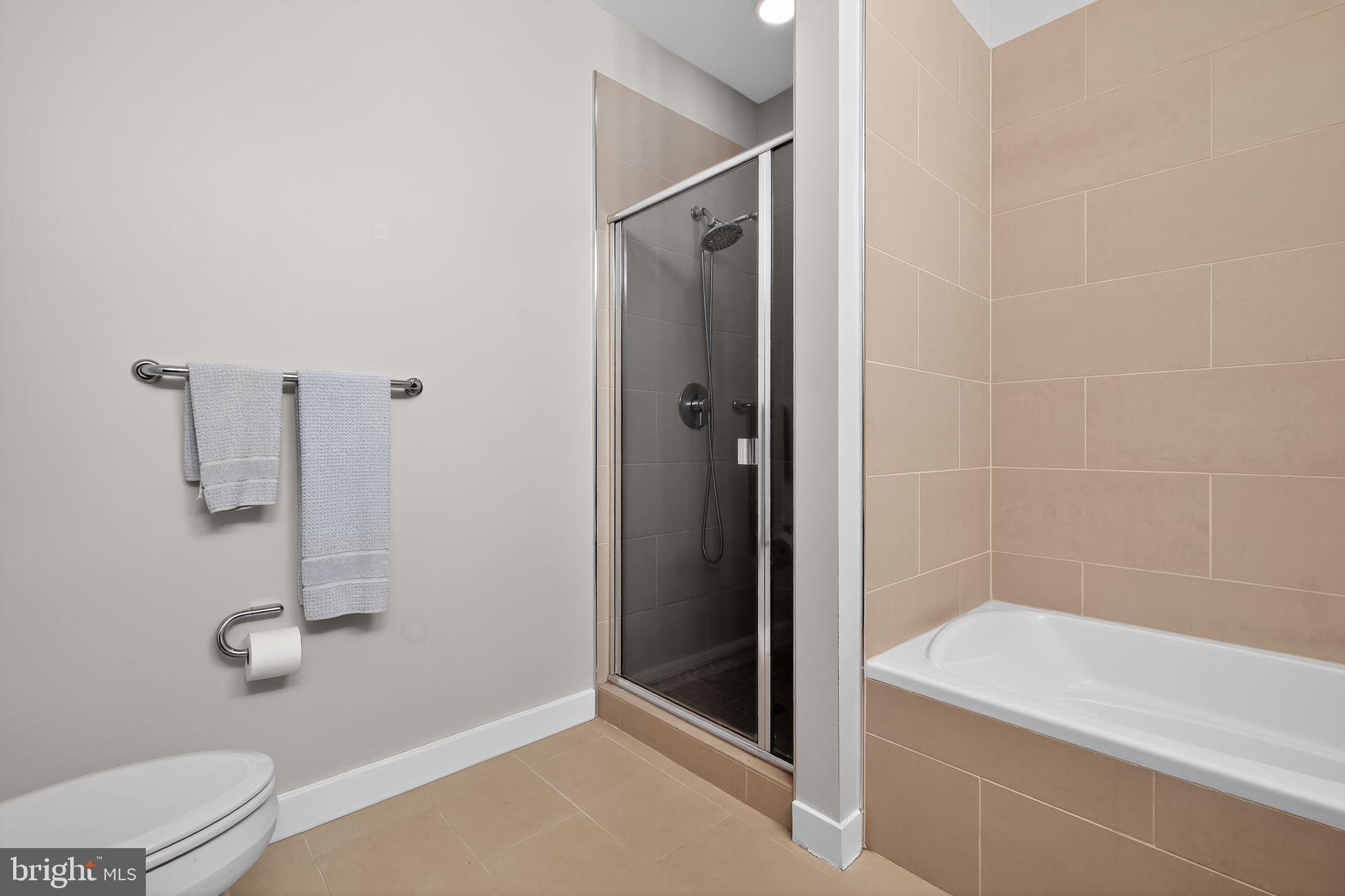 12025 New Dominion Parkway, Unit 311 Reston, VA 20190 - Photo 23 of 29 a bathroom with a shower and toilet