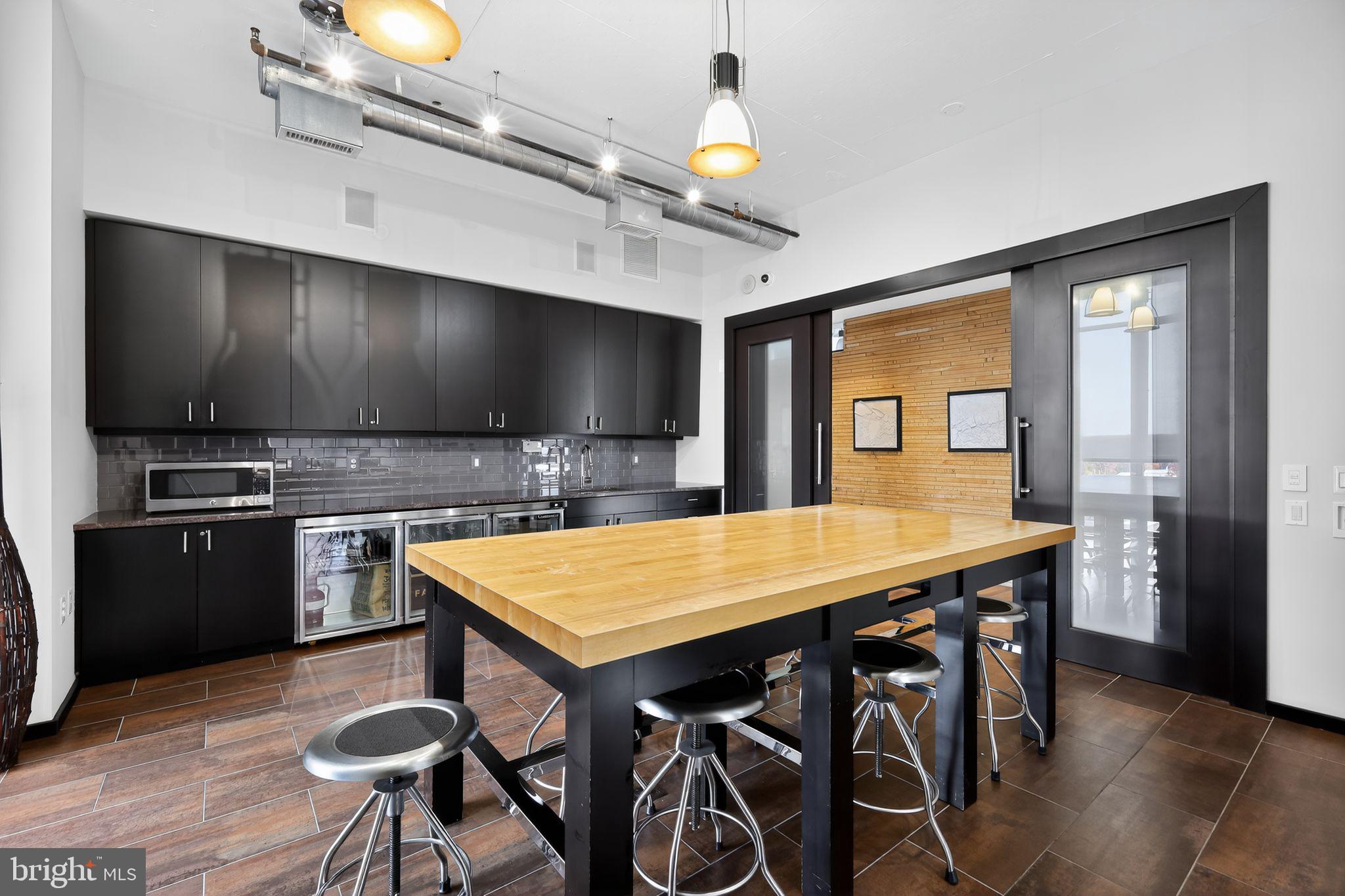 12025 New Dominion Parkway, Unit 311 Reston, VA 20190 - Photo 24 of 29 a kitchen with stainless steel appliances kitchen island granite countertop a stove a sink and a microwave